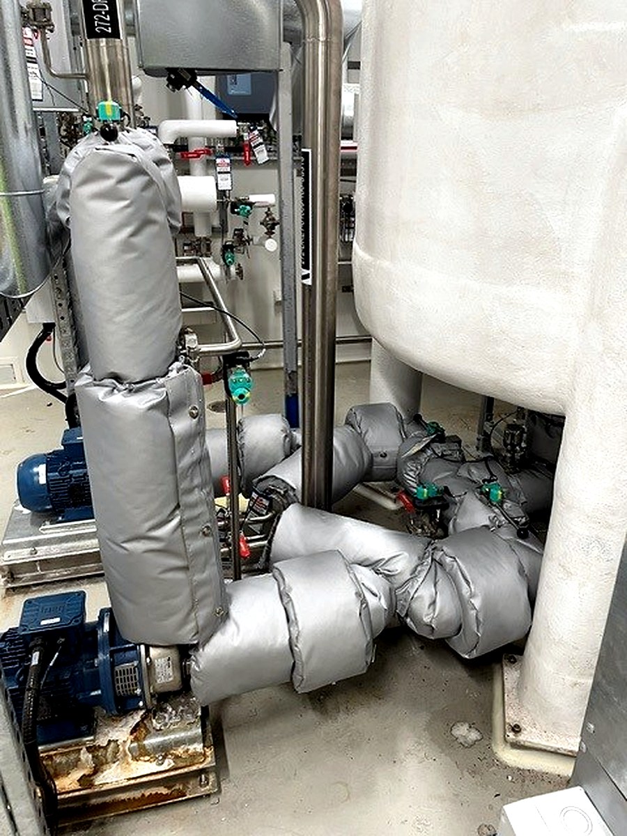 Thermal jackets on pump connections and pipework at the base of a large process vessel